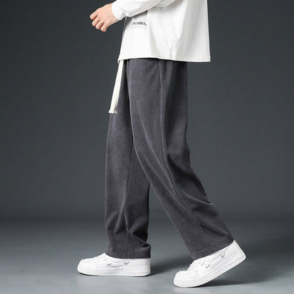 Pantaloni grigi in velluto a coste, indossati con maglia bianca e sneakers bianche, moda casual uomo, stile autunnale, abbigliamento confortevole.