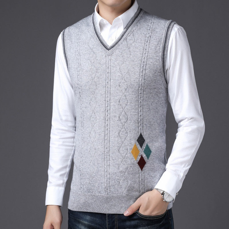 Gilet uomo grigio in maglia con motivo rombi colorati, indossato su camicia bianca. Moda maschile elegante, abbigliamento autunnale casual.