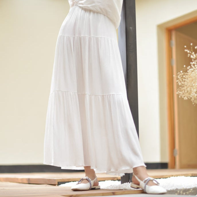 Gonna lunga bianca estiva, fluida e leggera, indossata con scarpe bianche eleganti. Moda donna, abbigliamento estivo, stile casual chic.