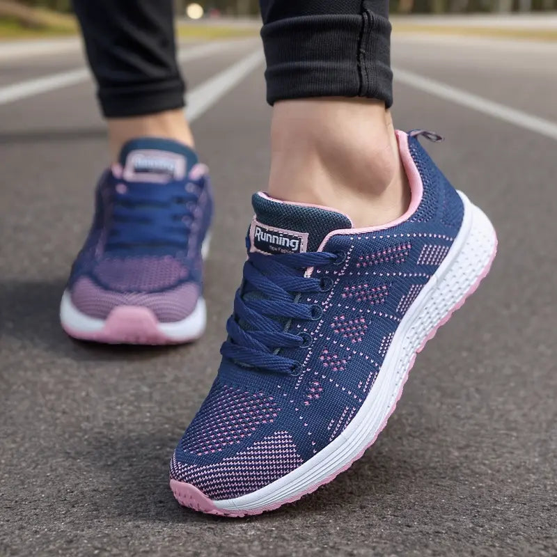 Scarpe da corsa blu e rosa su strada asfaltata, design traspirante, suola ammortizzata, ideali per jogging e fitness all'aperto.