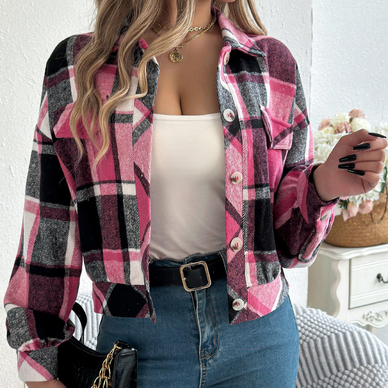 Giacca a quadri rosa e nera su donna con top bianco e jeans, moda autunnale, stile casual chic, accessori eleganti, sfondo interno.