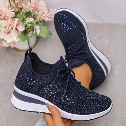 Scarpe da ginnastica blu scuro con dettagli a maglia, suola bianca e nera, tenute in mano. Sfondo con fiori decorativi.