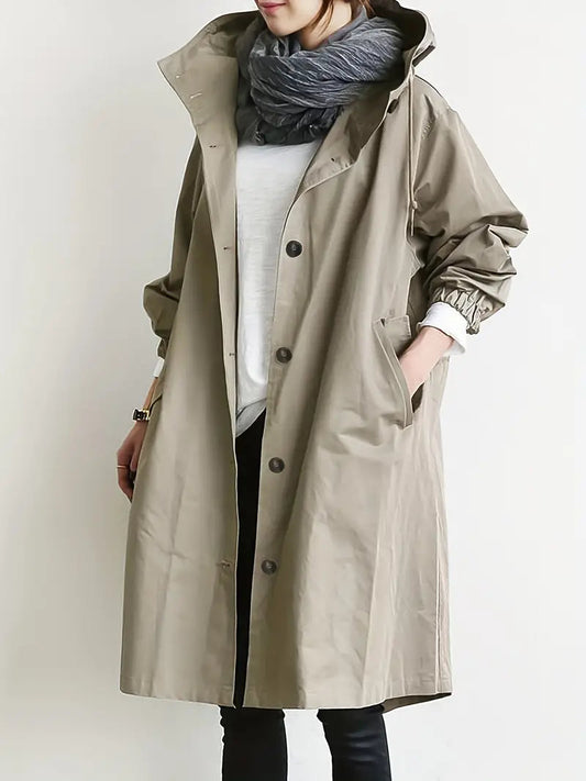 Cappotto beige lungo da donna con bottoni, indossato sopra maglia bianca e sciarpa grigia. Stile casual autunnale, moda femminile elegante.