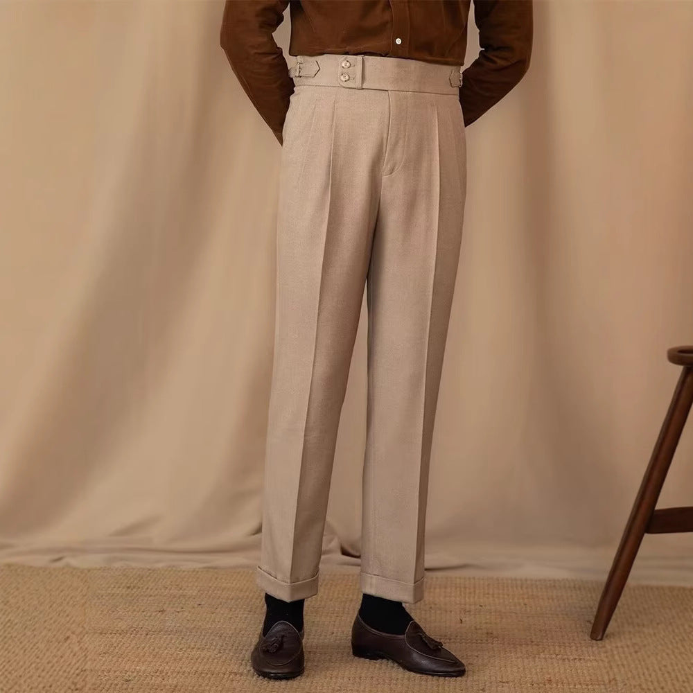 Pantaloni eleganti beige da uomo, stile classico, con pieghe frontali e risvolti. Abbinati a camicia marrone e mocassini scuri. Moda maschile sofisticata.