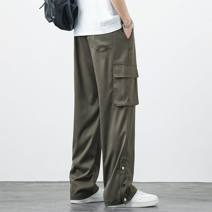 Pantaloni cargo verde oliva da uomo, tasche laterali ampie, stile casual, abbinati a scarpe bianche e zaino nero. Moda streetwear contemporanea.