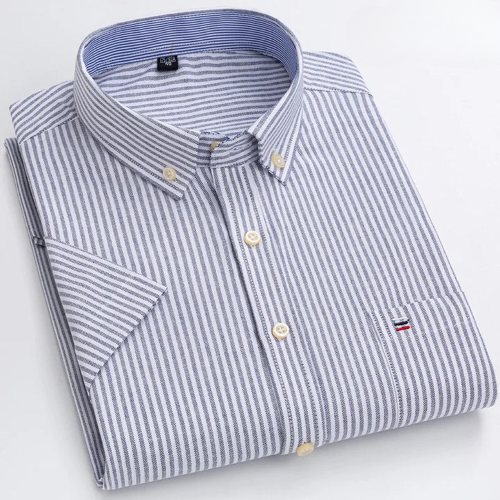Camicia a righe bianche e blu, colletto button-down, taschino con logo, piegata su sfondo bianco. Elegante abbigliamento maschile casual.