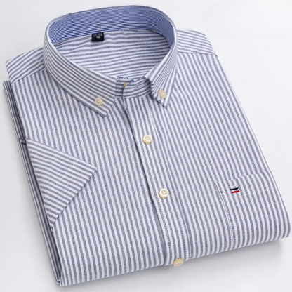 Camicia a righe bianche e blu, colletto button-down, taschino con logo, piegata su sfondo bianco. Elegante abbigliamento maschile casual.