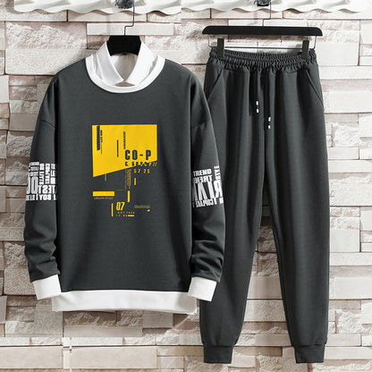 Completo sportivo uomo grigio scuro, felpa con grafica gialla e pantaloni elastici. Moda casual, abbigliamento comodo, stile urbano moderno.