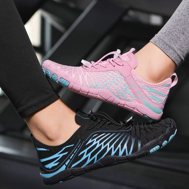 Scarpe da ginnastica minimaliste, una rosa e una nera, con design a strisce blu, indossate su tapis roulant. Scarpe sportive leggere e traspiranti.