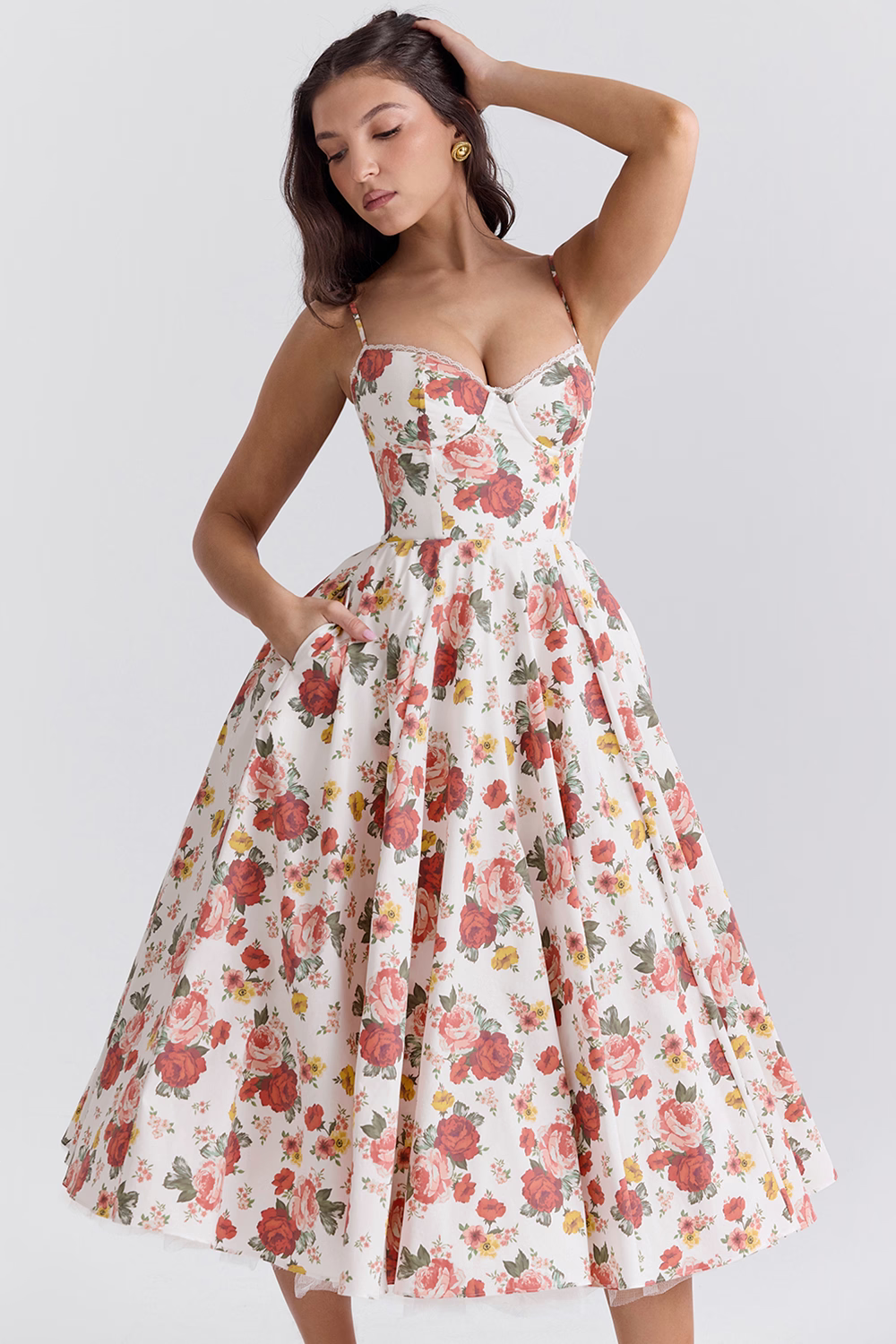 Abito estivo floreale donna, stile vintage anni '50, con spalline sottili e gonna ampia. Motivo a rose rosse su sfondo bianco. Moda elegante retrò.