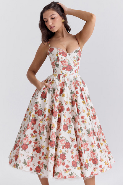 Abito estivo floreale donna, stile vintage anni '50, con spalline sottili e gonna ampia. Motivo a rose rosse su sfondo bianco. Moda elegante retrò.