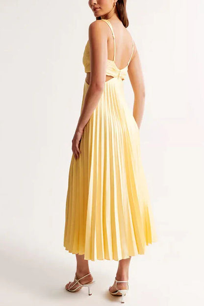 Abito lungo giallo plissettato con spalline sottili, schiena scoperta, indossato da una donna. Moda elegante estiva, abbigliamento femminile chic.