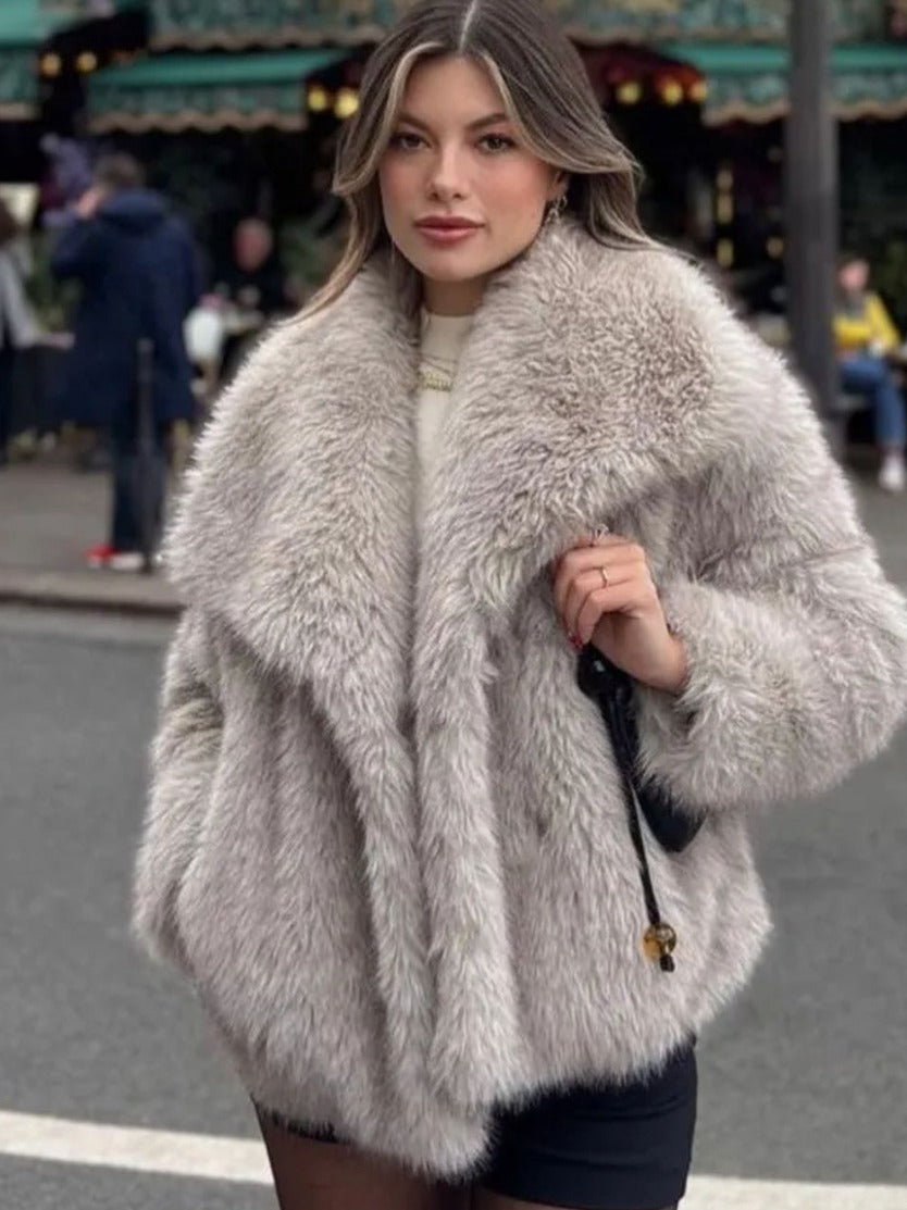 Donna con cappotto di pelliccia grigia in strada cittadina, moda invernale elegante, look casual chic, tendenze abbigliamento femminile.