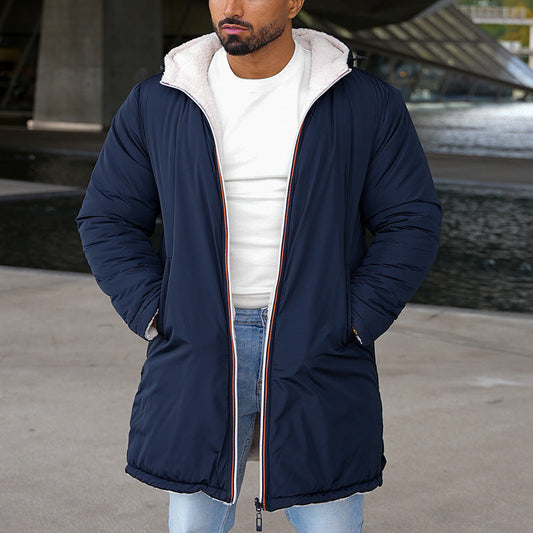 Giacca invernale blu scuro con cappuccio foderato in pelliccia sintetica, indossata da uomo su sfondo urbano. Moda maschile, abbigliamento caldo.