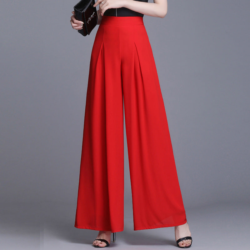 Pantaloni palazzo rossi eleganti, vita alta, tessuto fluido, abbinati a sandali neri e pochette. Moda donna, abbigliamento chic.