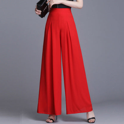 Pantaloni palazzo rossi eleganti, vita alta, tessuto fluido, abbinati a sandali neri e pochette. Moda donna, abbigliamento chic.