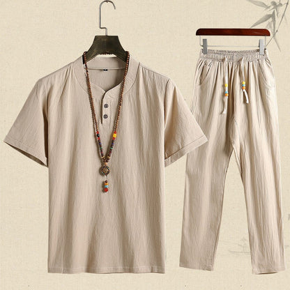 Completo estivo uomo in cotone beige, composto da maglietta a maniche corte e pantaloni, con collana etnica decorativa. Abbigliamento casual elegante.