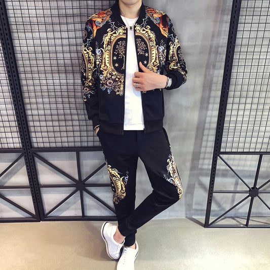 Tuta sportiva uomo elegante con motivi barocchi, giacca e pantaloni neri, scarpe bianche, moda casual, abbigliamento maschile trendy.