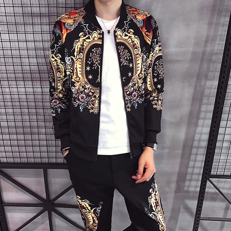 Giacca bomber uomo con motivo barocco, colori vivaci su sfondo nero, abbinata a pantaloni coordinati. Stile moda urbana, tendenza 2023.