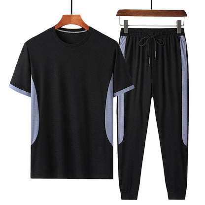 Completo sportivo uomo nero, maglietta e pantaloni con dettagli grigi, abbigliamento casual estivo, tessuto traspirante, moda fitness.
