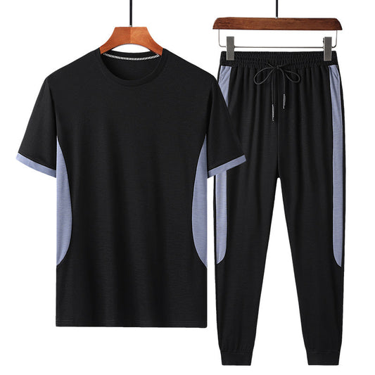 Completo sportivo uomo nero, maglietta e pantaloni con dettagli grigi, abbigliamento casual estivo, tessuto traspirante, moda fitness.