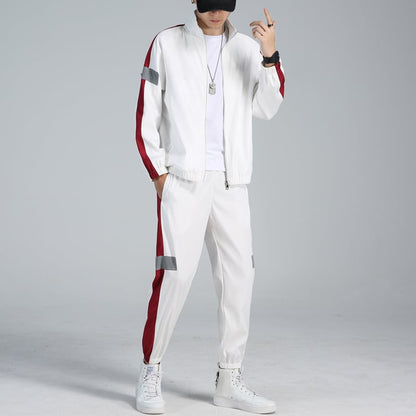 Uomo in tuta sportiva bianca con strisce rosse, cappellino nero e scarpe da ginnastica bianche. Moda casual, abbigliamento sportivo uomo.