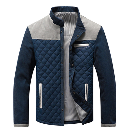 Giacca trapuntata blu da uomo con dettagli grigi, tasche laterali bianche, chiusura a bottoni, ideale per moda autunnale e invernale.