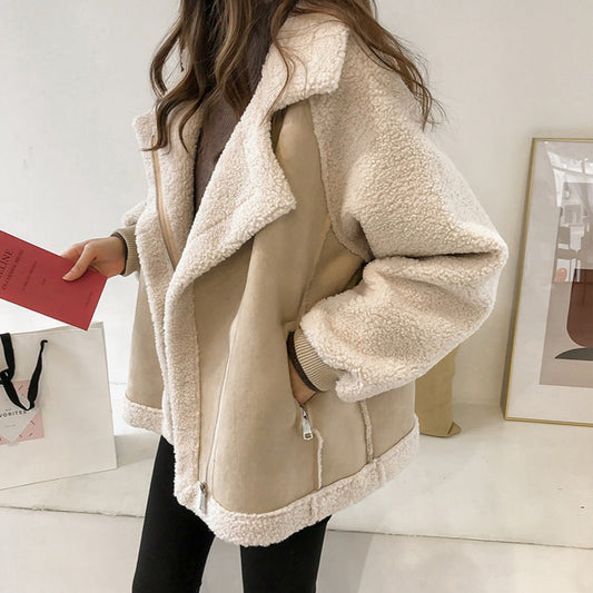 Donna con giacca in shearling beige, tasche con zip, tiene una busta rossa. Moda invernale, abbigliamento casual, stile elegante e caldo.