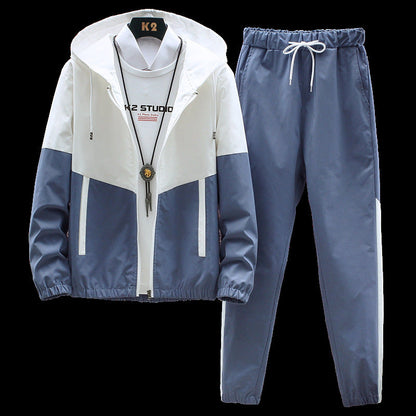 Tuta sportiva uomo bianca e blu, giacca con cappuccio e pantaloni con elastico, stile casual, ideale per attività all'aperto e tempo libero.