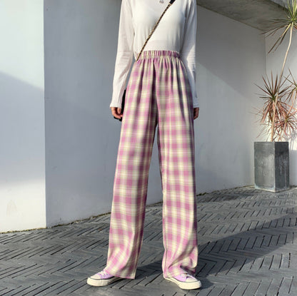 Pantaloni a quadri rosa e bianchi, stile casual, indossati con maglia bianca a maniche lunghe. Look moderno e alla moda per la stagione autunnale.