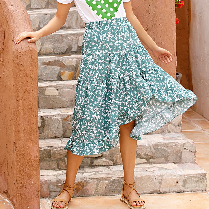 Gonna lunga verde a fiori bianchi, indossata con sandali e maglietta bianca. Moda estiva femminile, look casual e fresco.