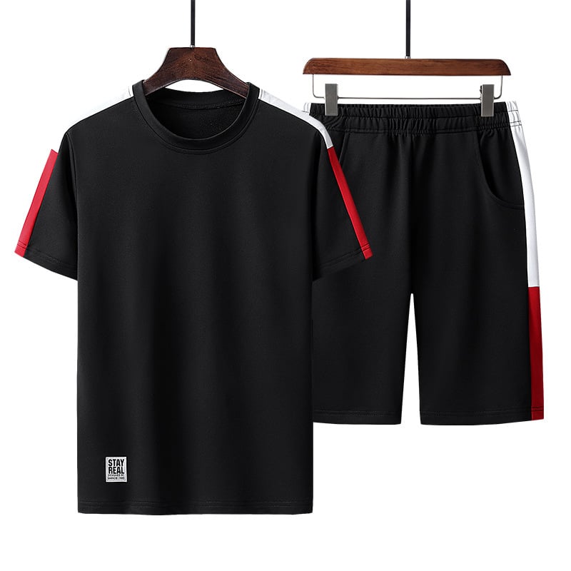 Completo sportivo uomo nero, maglietta e pantaloncini con dettagli rossi e bianchi, tessuto traspirante, ideale per allenamento e tempo libero.