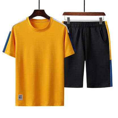 Completo sportivo uomo, maglietta gialla e pantaloncini neri, design moderno, tessuto traspirante, ideale per allenamento e tempo libero.