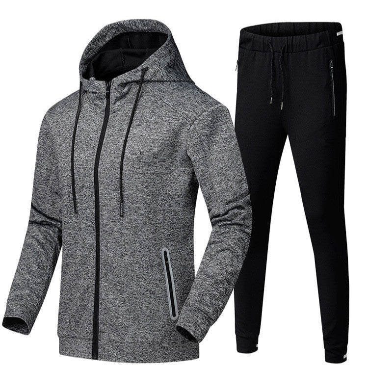 Tuta sportiva uomo, giacca grigia con cappuccio e pantaloni neri, abbigliamento fitness, moda casual, tessuto traspirante, stile moderno.