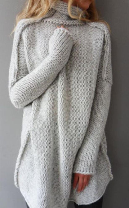 Maglione oversize grigio in lana, lavorato a maglia, con collo alto e maniche lunghe. Moda autunnale, abbigliamento caldo e confortevole.