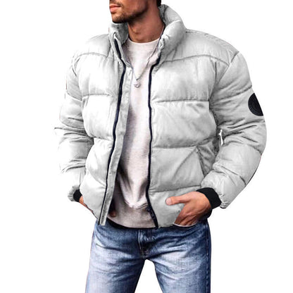 Giacca invernale uomo bianca imbottita, stile casual, con colletto alto e tasche, abbinata a jeans blu. Moda maschile autunno inverno.