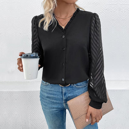 Donna con camicia nera elegante, maniche trasparenti, tiene tazza da caffè e borsa beige. Moda casual chic, outfit autunnale.