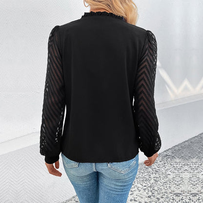 Donna di spalle con camicetta nera a maniche lunghe in pizzo e jeans, in un ambiente moderno. Moda femminile elegante, abbigliamento casual chic.