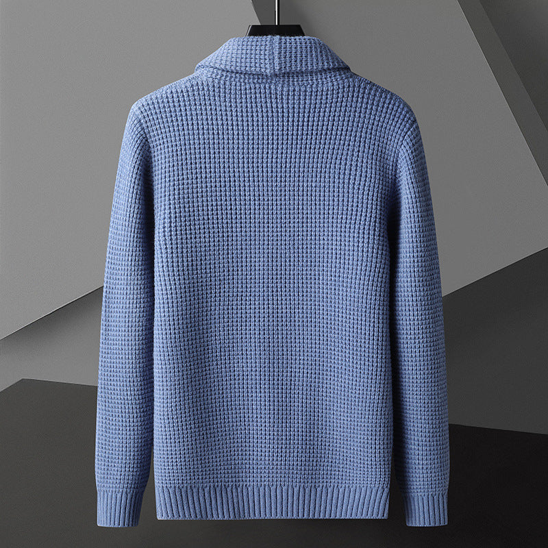 Maglione blu in lana lavorata a maglia, design elegante e moderno, sfondo geometrico grigio. Moda uomo, abbigliamento invernale di tendenza.