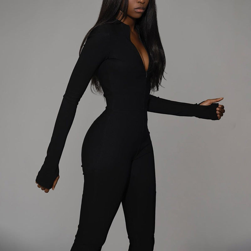 Donna in tuta nera aderente su sfondo grigio, moda elegante, abbigliamento femminile moderno, stile minimalista, tendenza autunno inverno.