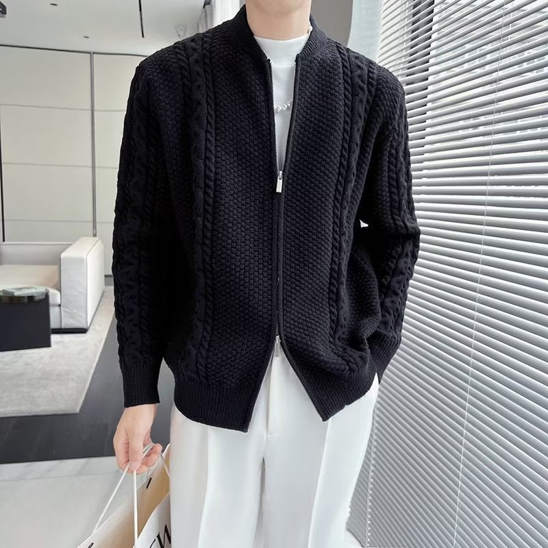 Cardigan nero a maglia intrecciata, indossato da una persona in piedi vicino a una finestra. Design elegante, ideale per moda autunnale e invernale.