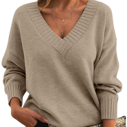 Maglione beige donna con scollo a V, maniche lunghe, indossato con collana a strati. Stile casual elegante, moda autunno inverno.