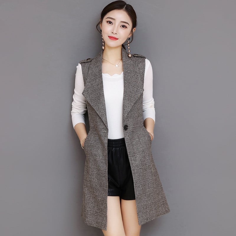 Donna con gilet grigio elegante, camicia bianca e pantaloncini neri. Moda femminile autunnale, abbigliamento casual chic, tendenze 2023.