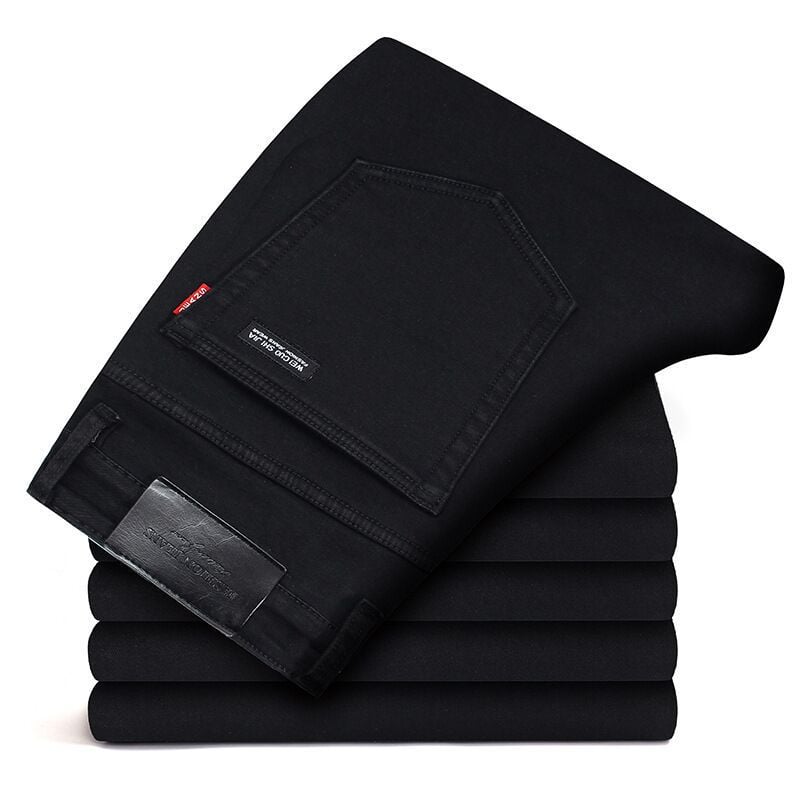 Jeans neri piegati su una pila, tasca posteriore visibile, etichetta in pelle. Moda uomo, abbigliamento casual, pantaloni denim eleganti.