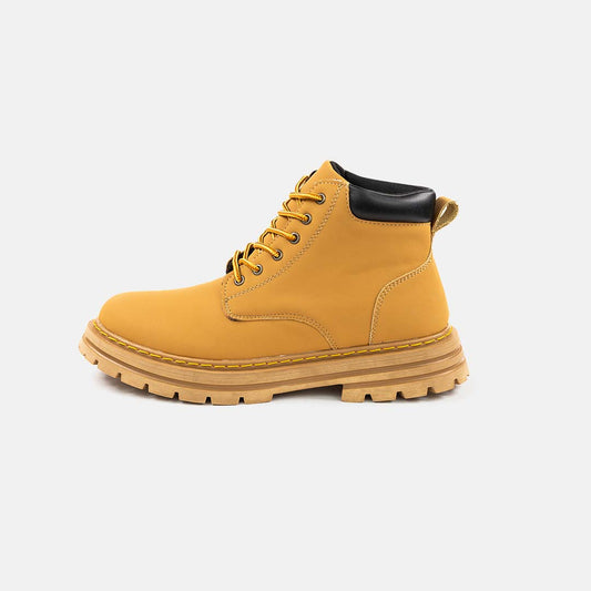 Scarponcino giallo in pelle con suola robusta, lacci neri e dettagli cuciti, ideale per moda autunnale e invernale. Scarpe casual resistenti.