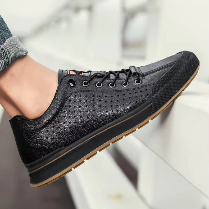 Scarpa da ginnastica nera in pelle traforata, suola in gomma marrone, indossata su panchina bianca. Scarpe casual uomo, moda urbana.