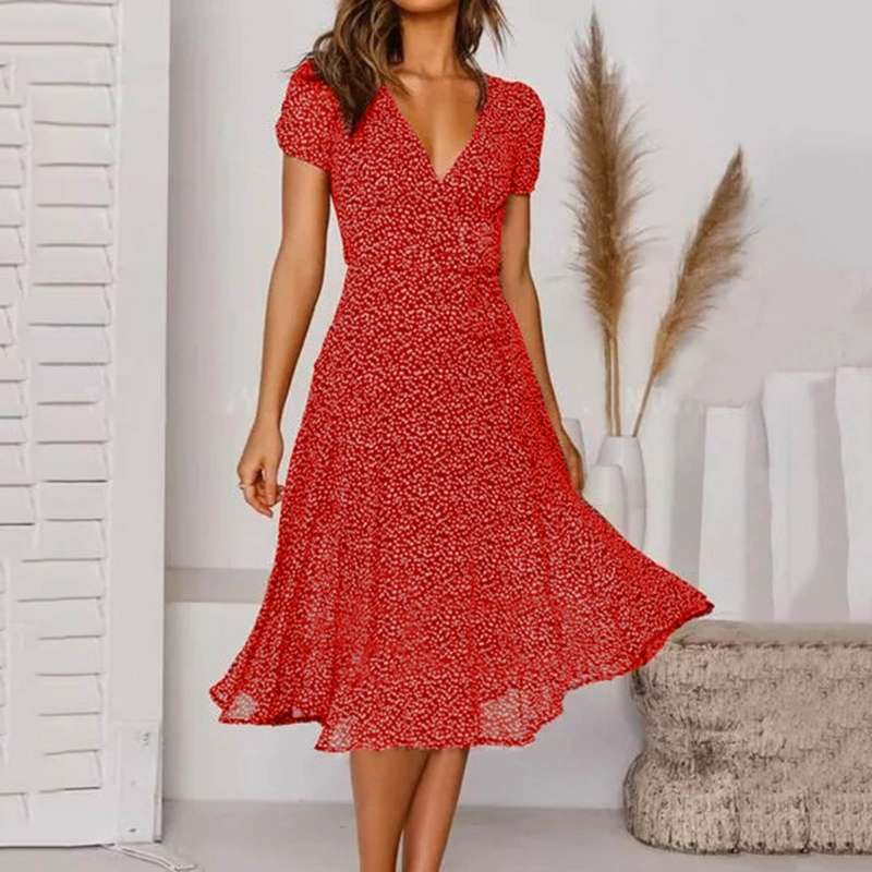 Abito rosso a fiori con scollo a V, maniche corte, indossato da una donna in un ambiente moderno. Elegante e alla moda, perfetto per l'estate.