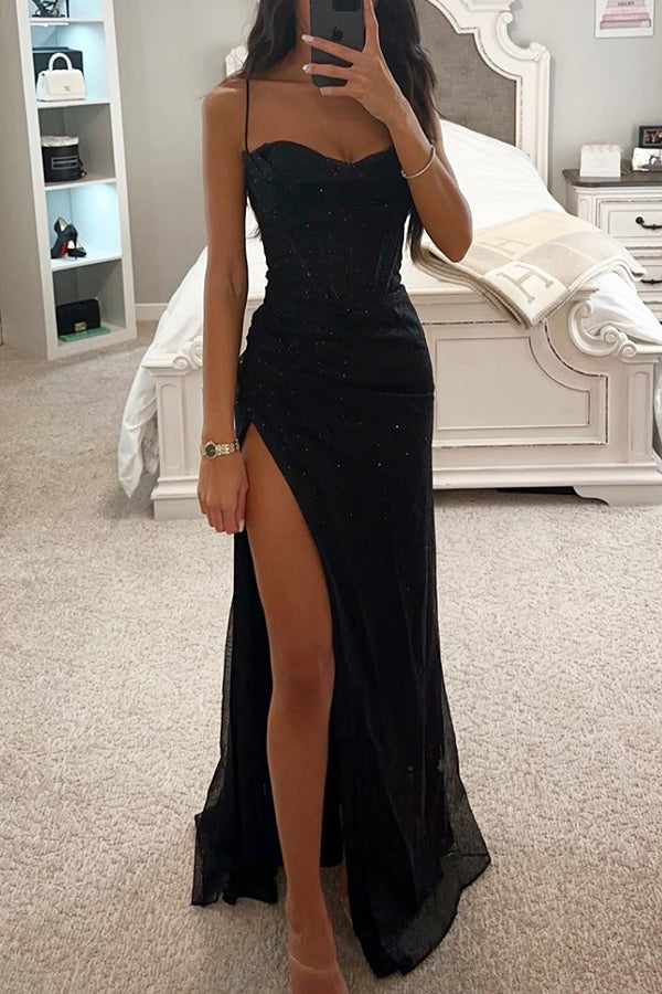 Donna in abito lungo nero elegante con spacco alto, in camera da letto moderna. Vestito da sera glamour, moda femminile, stile sofisticato.