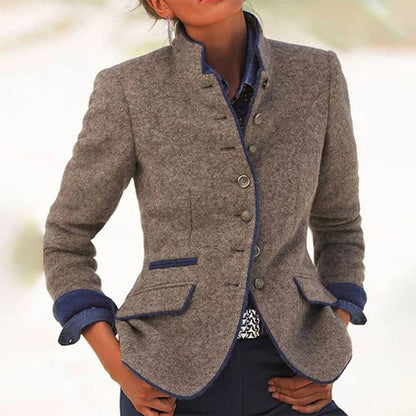 Giacca elegante in lana grigia con bottoni, dettagli blu e tasche, indossata su camicia denim. Moda autunnale donna, stile casual chic.