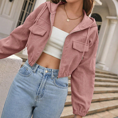 Donna con giacca rosa a coste, top bianco e jeans a vita alta. Moda casual femminile, abbigliamento trendy, stile urbano.